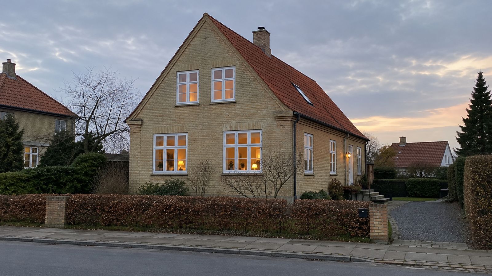 Dansk villa på stille vej i blødt aftenlys